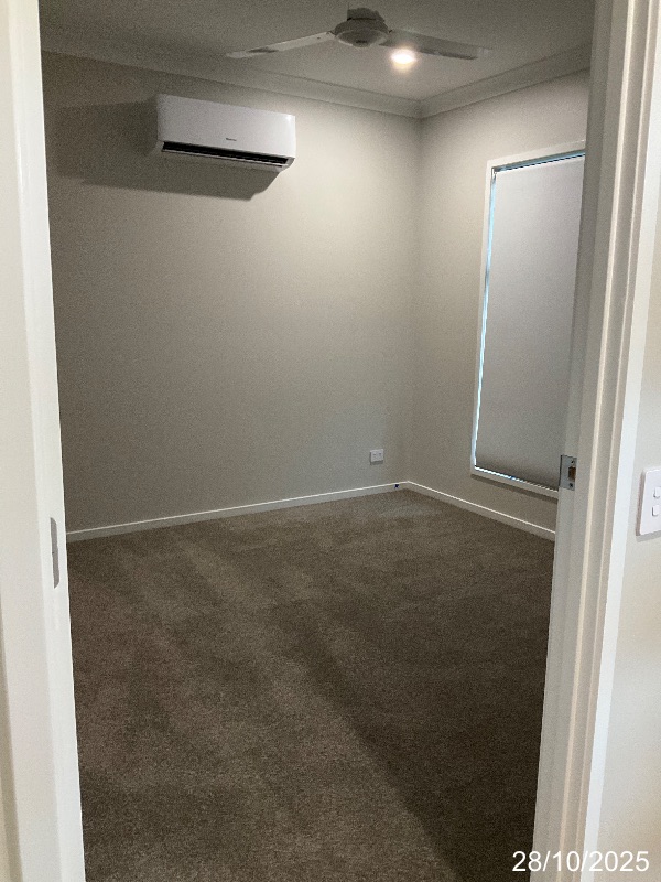 Bedroom with a single downlight near the corner and a ceiling fan