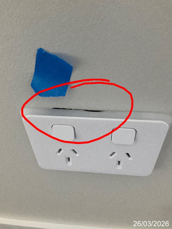 Red inspection circle around unfinished wall opening above a power point