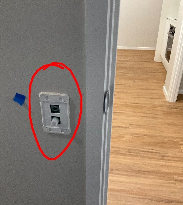 Wall light-switch assembly with its cover missing and a red inspection circle
