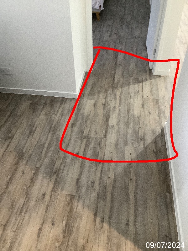 Red inspection outline marking a section of hallway flooring beside a doorway