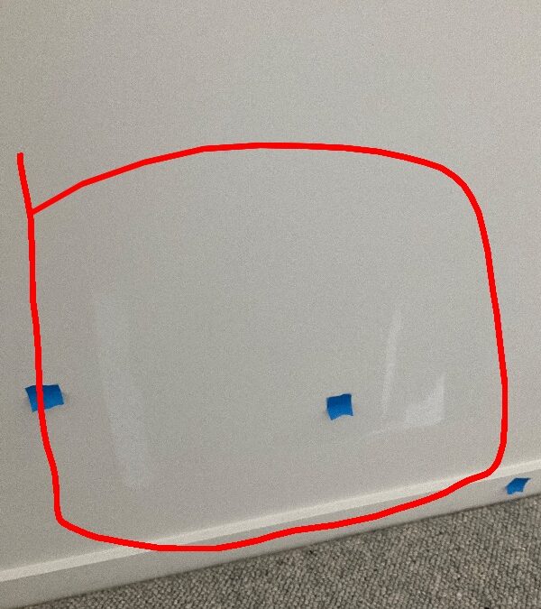 Wall paint finish marked with red outline and blue tape