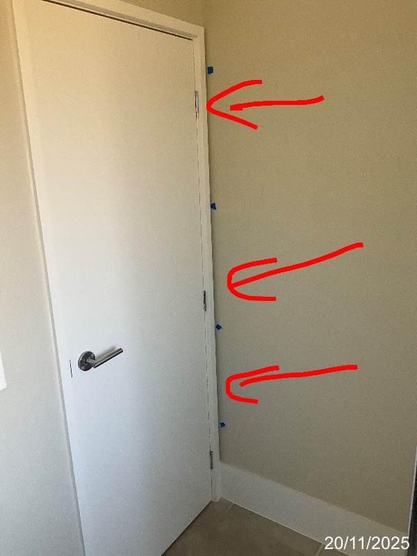 Red arrows marking the plaster finish beside a bathroom door architrave