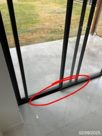 Lower section of a sliding door, with the reported bottom-track binding area marked in a GoInspect sample inspection photo