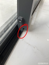 Close-up of the sliding-door bottom corner and track, with the reported area marked in a GoInspect sample inspection photo